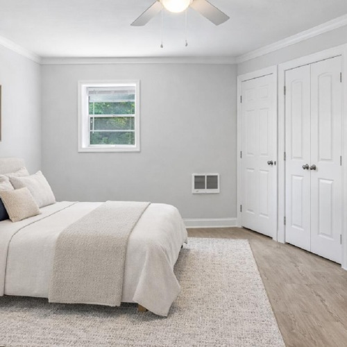 a bedroom with a bed and a fan