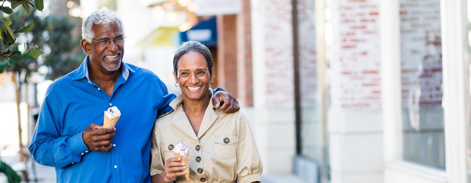 a man and a woman walking with ice cream